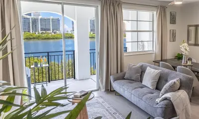 a living room with a couch and a large window at Serene Waterfront Condo - Bayview, pool & tennis in Aventura