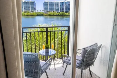 a balcony with chairs and a table with a view at Serene Waterfront Condo - Bayview, pool & tennis in Aventura