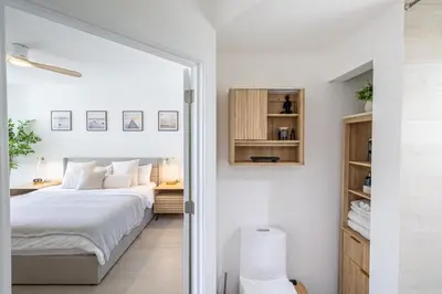 a white bedroom with a bed and a desk at Serene Waterfront Condo - Bayview, pool & tennis in Aventura
