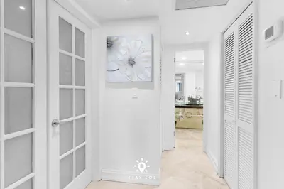 a white hallway with a door and a painting on the wall at Luxury by the Sea- 2BR Pool & Gym -Hollywood in Hollywood