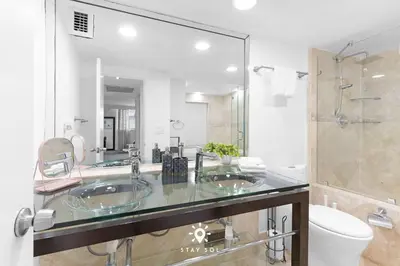 a bathroom with two sinks and a large mirror at Luxury by the Sea- 2BR Pool & Gym -Hollywood in Hollywood