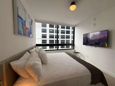 a bedroom with a bed and a large window at Downtown Miami 1BR Walk to Bayside Kaseya Gym Pool in Miami