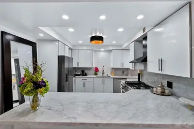 a kitchen with white cabinets and a vase of flowers on a counter at Villa 800 - 3 BEDROOM - 3 AND A HALF BATHROOMS -6 BEDS- Spa like Retreat Saline Pool & Jacuzzi in Miami