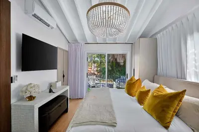 a bedroom with a large white bed with yellow pillows at Villa 800 - 3 BEDROOM - 3 AND A HALF BATHROOMS -6 BEDS- Spa like Retreat Saline Pool & Jacuzzi in Miami