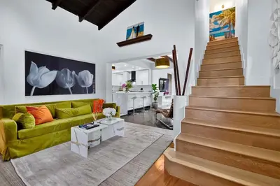 a living room with a green couch and stairs at Villa 800 - 3 BEDROOM - 3 AND A HALF BATHROOMS -6 BEDS- Spa like Retreat Saline Pool & Jacuzzi in Miami