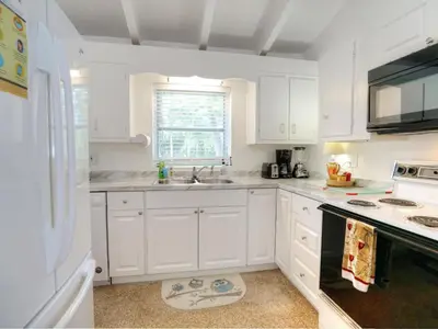 a kitchen with white cabinets and a sink and a window at Holiday Home Guest House at the Ocean by Interhome in Fort Lauderdale