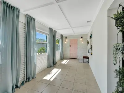 a hallway with blue curtains and a pink door at Holiday Home 2BR - 2 bath Beheizter Pool- Familien-Haustierfreundlicher Spaß by Interhome in Fort Lauderdale