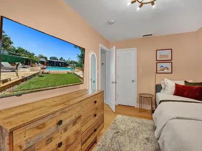 a bedroom with a large tv on the wall at Holiday Home 2BR - 2 bath Beheizter Pool- Familien-Haustierfreundlicher Spaß by Interhome in Fort Lauderdale