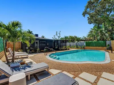a swimming pool in a yard with a house at Holiday Home 2BR - 2 bath Beheizter Pool- Familien-Haustierfreundlicher Spaß by Interhome in Fort Lauderdale