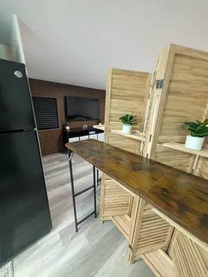 a kitchen with a wooden table and a refrigerator at PrimeStay Modern Studio in Prime Location in Hollywood