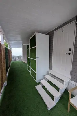 a garage with stairs and a door and grass at PrimeStay Modern Studio in Prime Location in Hollywood