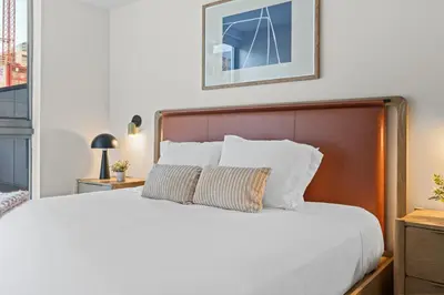 a bedroom with a white bed with a wooden headboard at Modern Condo in Downtown Miami Near Bayside in Miami