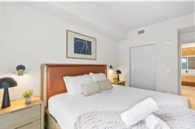 a bedroom with a large white bed and a dresser at Modern Condo in Downtown Miami Near Bayside in Miami