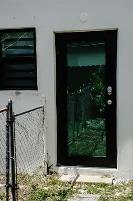 a black door on a house with a fence at Central location in Cutler Bay