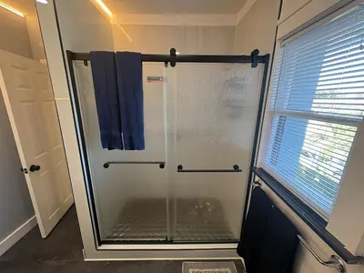 a shower with a glass door in a bathroom at Villa Habana in Miami