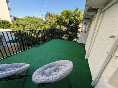 a balcony with two bean bag chairs on a green floor at Villa Habana in Miami