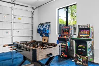 a game room with a large wooden table and video games at Casa Monstera Heated Saltwater Pool Game Room Golf in Fort Lauderdale