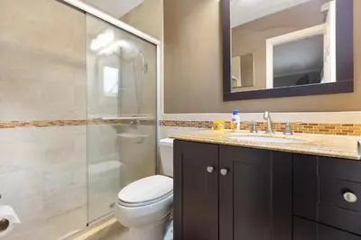 a bathroom with a toilet and a shower and a sink at Private Oasis with Heated Saltwater Pool Tropical Backyard in Dania Beach