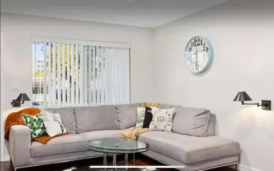 a living room with a couch and a glass table at Private Oasis with Heated Saltwater Pool Tropical Backyard in Dania Beach