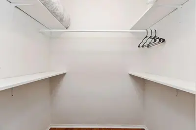 a white walk in closet with white shelves at Private Oasis with Heated Saltwater Pool Tropical Backyard in Dania Beach