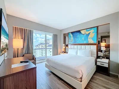 a hotel room with a large bed and a desk at Fort Lauderdale Beach Luxury - Ocean View Condo in Fort Lauderdale