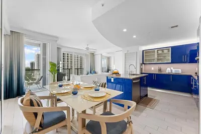 a kitchen with blue cabinets and a table and chairs at W Fort Lauderdale Corner Unit with Ocean View and Resort Access - 2BR 2BA in Fort Lauderdale