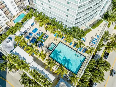 an overhead view of a hotel with palm trees and a pool at W Fort Lauderdale Corner Unit with Ocean View and Resort Access - 2BR 2BA in Fort Lauderdale