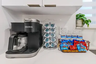 a coffee maker on a counter next to bottled water at 4 Bedroom Villa Pool Game Room By Beach & Hard Rock in Pembroke Pines