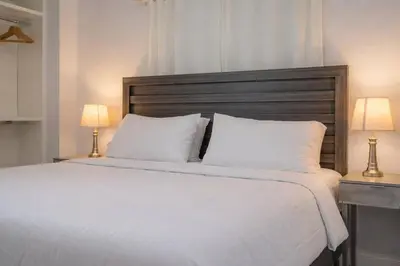 a bedroom with a large white bed with two lamps at 4 Bedroom Villa Pool Game Room By Beach & Hard Rock in Pembroke Pines