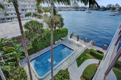 an aerial view of a swimming pool with palm trees at Fort Lauderdale Waterfront Condo! Pool and Marina Views in Fort Lauderdale