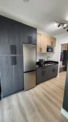a kitchen with wooden cabinets and a stainless steel refrigerator at Pop Art Loft in Hialeah