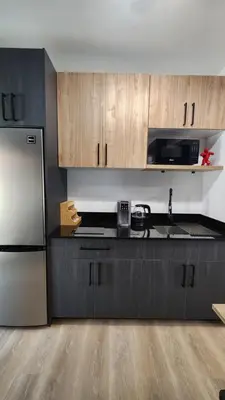 a kitchen with wooden cabinets and a stainless steel refrigerator at Pop Art Loft in Hialeah