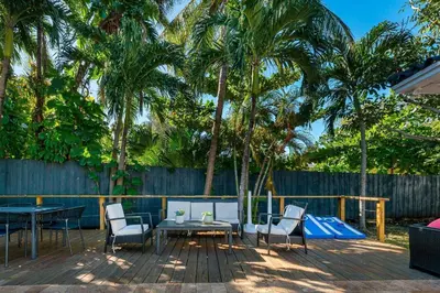 a patio with a table and chairs and palm trees at Harbor Beach in Fort Lauderdale