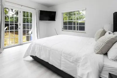a white bedroom with a large bed and windows at Harbor Beach in Fort Lauderdale