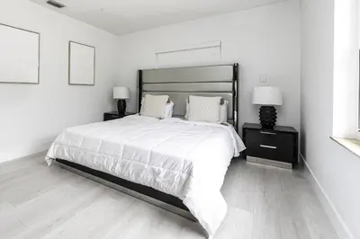 a white bedroom with a large bed with two lamps at Harbor Beach in Fort Lauderdale