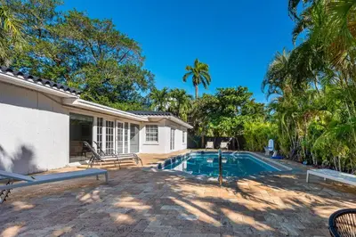 a house with a swimming pool and palm trees at Harbor Beach in Fort Lauderdale