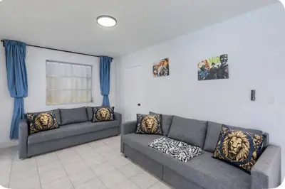 a living room with two couches and blue curtains at Eat Pray Love Villa in Hollywood