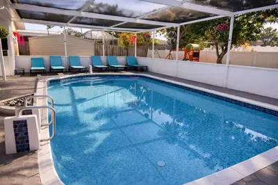 a large swimming pool with blue chairs on a building at Eat Pray Love Villa in Hollywood