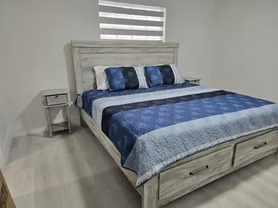 a bedroom with a large bed with a blue comforter at Sunrise Oasis in Sunrise