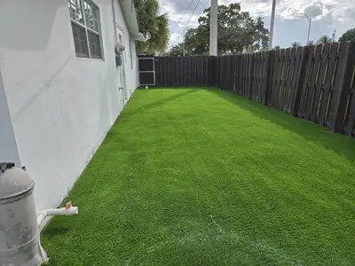 a backyard with a fence and green grass at Sunrise Oasis in Sunrise