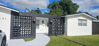 a house with a black and white fence at Sunrise Oasis in Sunrise