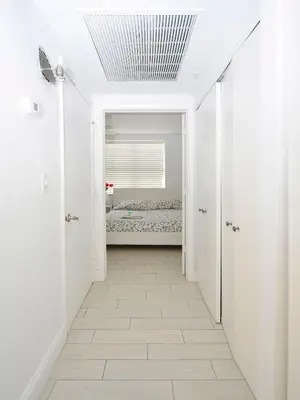 a hallway with a bed in a white room at Art Deco Ocean Drive Suites in Miami Beach