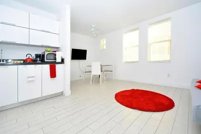 a white kitchen with a red rug on the floor at Art Deco Ocean Drive Suites in Miami Beach