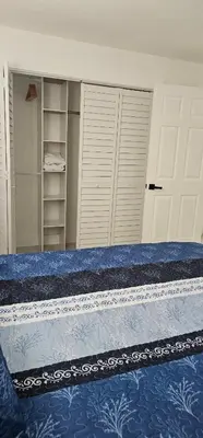 a bedroom with a bed and a door and shelves at Sunrise Oasis in Sunrise