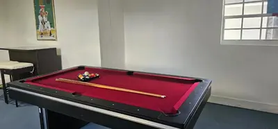 a pool table with two baseball bats on top of it at Sunrise Oasis in Sunrise