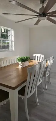 a dining room table with white chairs and a ceiling fan at Sunrise Oasis in Sunrise