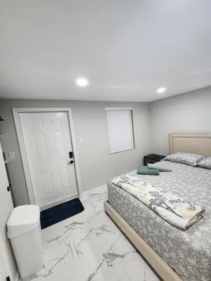 a bedroom with two beds and a toilet and a door at Amazing room in Hollywood in Carver Ranches