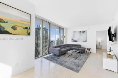 a living room with a couch and large windows at Icon Brickell Penthouse Panoramic Skyline by IliosRentals in Miami