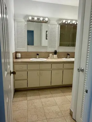a bathroom with two sinks and two mirrors at House across from Baptist Hospital in Sunset Corners