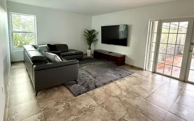 a living room with a couch and a flat screen tv at House across from Baptist Hospital in Sunset Corners